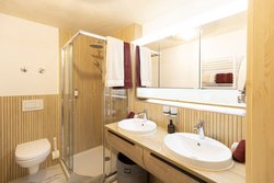 Eine moderne Badezimmerausstattung, eine elegante Glasdusche und hochwertige Granitfliesen sind in dem Badezimmer vorhanden.