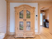 Ein großer Schrank mit Bauernmalerei ist nicht nur ein optisches Highlight, sondern bietet genug Stauraum für Ihre Garderobe. Nichts liegt im Weg und für angenehme Ordnung ist gesorgt.